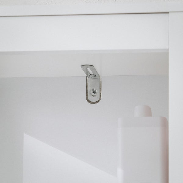 Detailansicht eines Möbelbefestigungsbeschlags an einem weißen Möbelstück