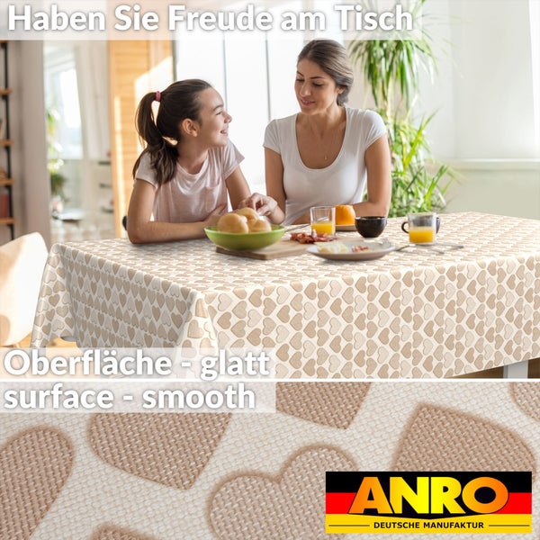 Abwaschbare Tischdecke mit Herzmuster und glatter Oberfläche auf einem Frühstückstisch mit Frau und Kind in hellem Raum. ANRO Logo.