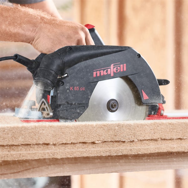 Handgeführte Mafell K 65 cc Handkreissäge beim Schneiden einer Holzfaserdämmplatte mit integrierter Staubabsaugung
