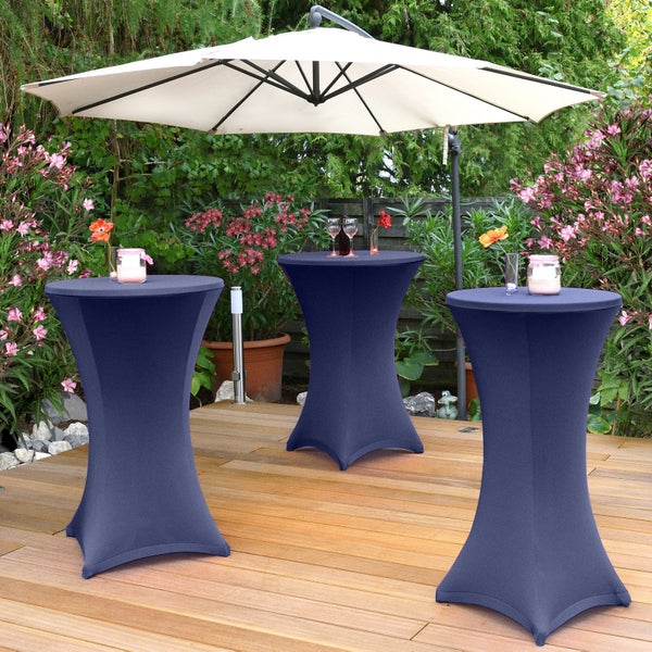 Szene im Freien mit drei Stehtischen mit Husse und einem Sonnenschirm.