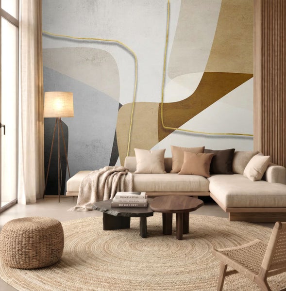Fototapete mit abstraktem geometrischem Muster in einem hellen Wohnzimmer mit modernem Sofa, Holztisch und rundem Teppich.