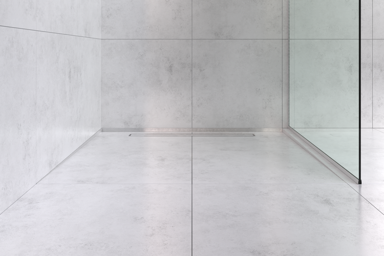 Moderne bodengleiche Dusche mit großen grauen Fliesen an Boden und Wand, einer minimalistischen Duschrinne und einer gläsernen Trennwand.