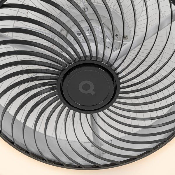 Nahaufnahme eines schwarzen Ventilator-Schutzgitters mit spiralförmigen Lamellen und einer runden Abdeckung in der Mitte.