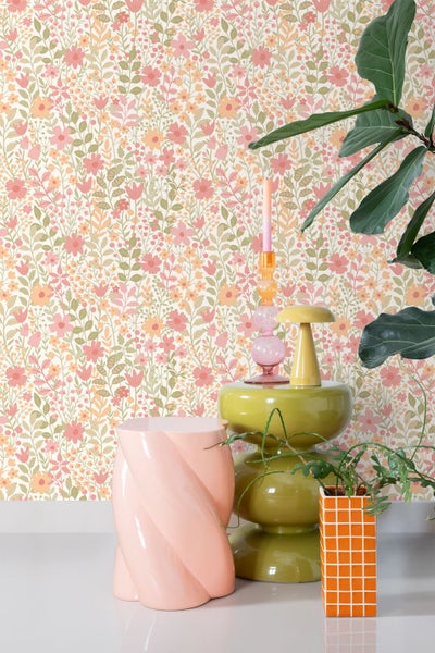 Szene mit Blumentapete, Beistelltisch, Kerzenständer und Zimmerpflanze