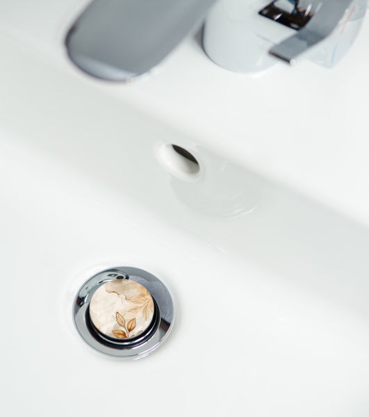 Detailansicht eines Waschbeckens mit Abfluss und floralem Design