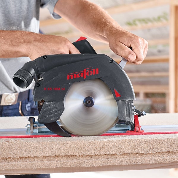 Eine Mafell Akku Handkreissäge K 65 18M bl bei der Arbeit mit einer Führungsschiene an einer Holzplatte.