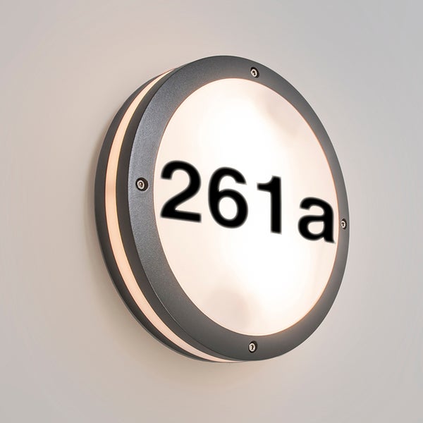 Runde Hausnummernleuchte für die Außenwand in Anthrazit mit weißem Leuchtfeld und schwarzer Nummer 261a.