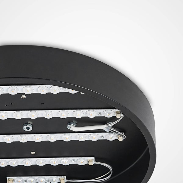 Detail der Innenseite einer runden schwarzen LED-Deckenleuchte mit mehreren Reihen von LED-Modulen und sichtbarer Verkabelung.