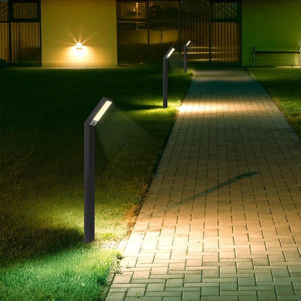 Beleuchteter Weg mit mehreren Wegeleuchten in einem Garten.