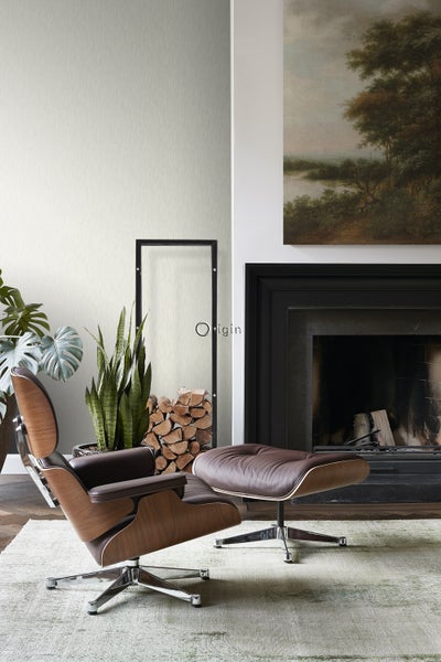 Wohnzimmer mit Sessel, Hocker, Kamin und Dekoration