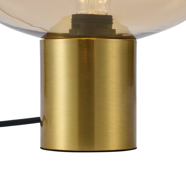 Tischleuchte mit zylindrischem Metallsockel in Messingoptik und Glasschirm.