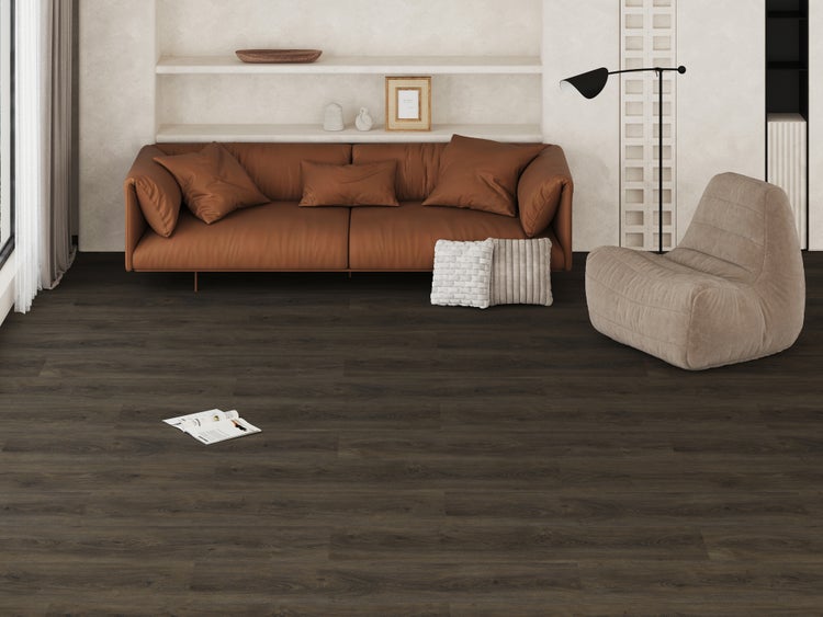 Moderner Wohnraum mit dunklem Bodenbelag in Holzoptik, braunem Sofa, beigem Sessel und eingebauten Wandregalen in einer hellen Umgebung.