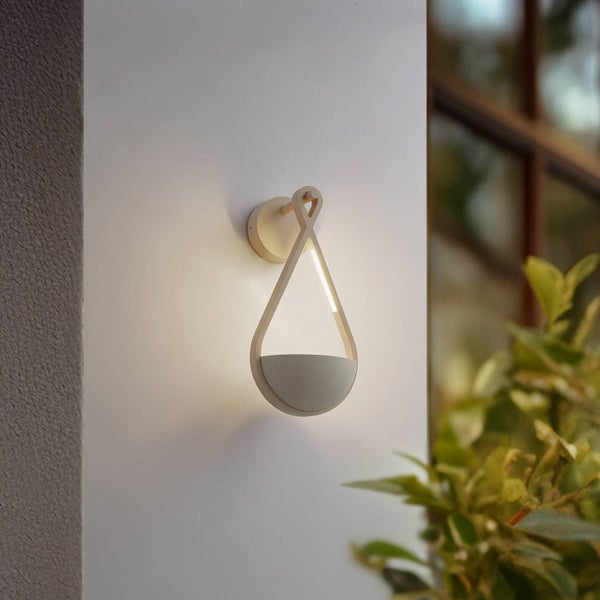 Moderne tropfenförmige Außenwandleuchte mit LED-Licht, montiert an einer weißen Wand.