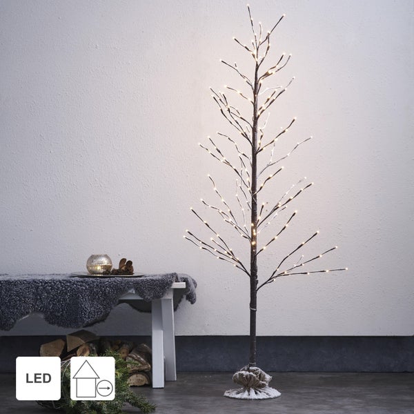 Dekorativer LED-Baum neben einer Bank mit einem Teelicht auf einem Tisch