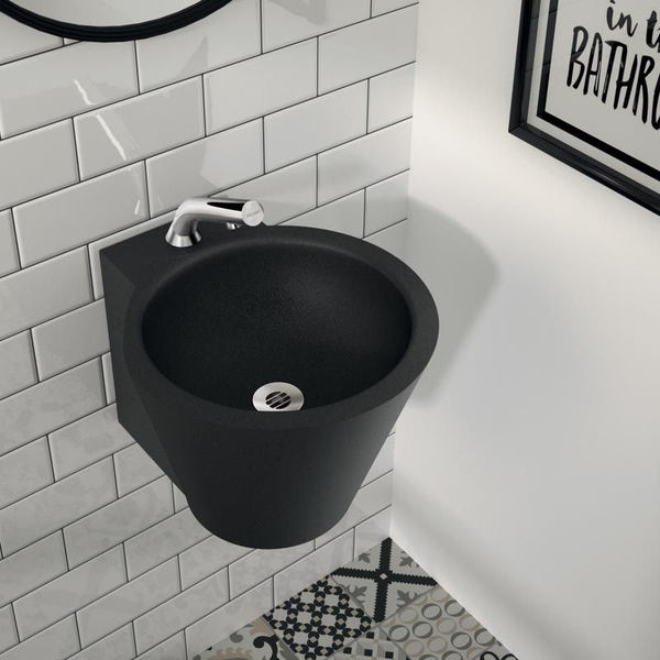 Rundes, wandhängendes Gäste-Waschbecken in Schwarz-Matt mit verchromter Armatur an einer weiß gefliesten Wand.
