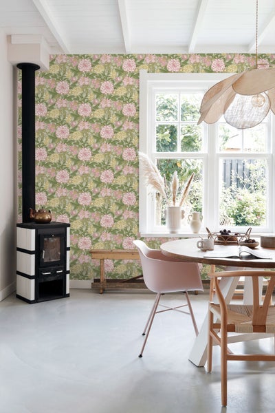 Heller Raum mit Ofen, Esstisch und Blumentapete