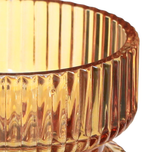 Nahaufnahme eines Teelichthalters aus Glas mit vertikaler Rillenstruktur.