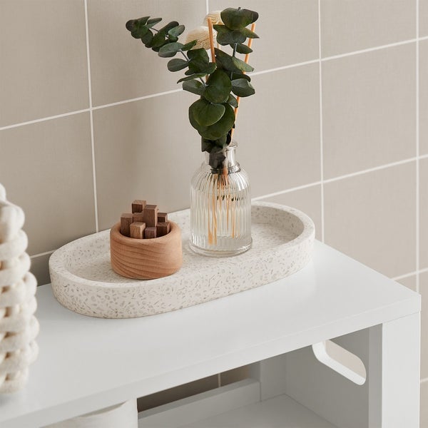 Dekorative Anordnung mit Schale, Duftstäbchen und Holzbehälter auf einem weißen Möbelstück