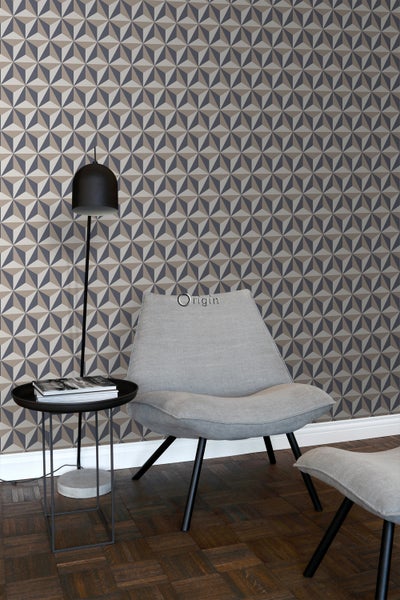 Wohnraum mit geometrischer Tapete, Sessel und Stehlampe