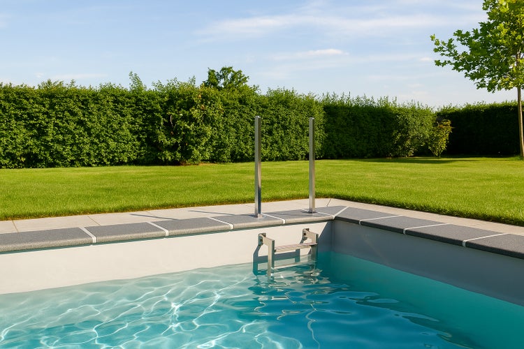 Schwimmbecken mit Poolleiter in einem Garten