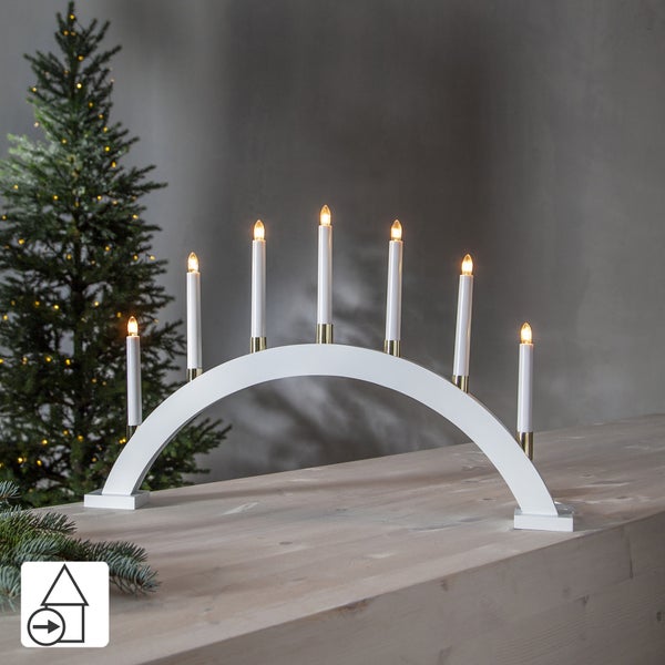 Drei LED Lichterbögen aus Holz und Kunststoff auf einem Tisch, daneben ein Weihnachtsbaum.