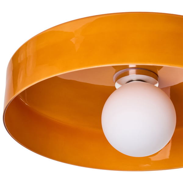 Deckenleuchte mit orangefarbenem Metallschirm und runder weißer Glühbirne.