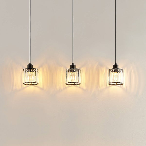 Drei Pendelleuchten mit durchsichtigem Lampenschirm hängen von der Decke