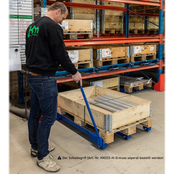 Mann transportiert Palette mit Rollwagen in einem Lagerregal