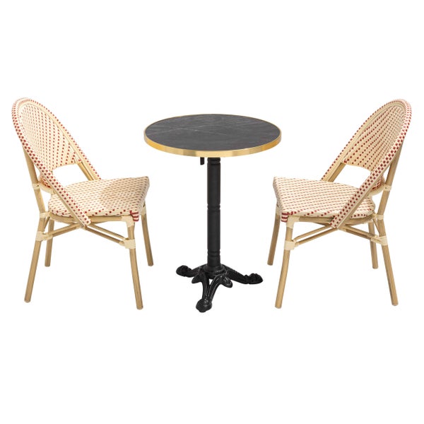 Bistrositzgruppe bestehend aus einem runden Tisch mit dunkler Platte und Goldrand sowie zwei geflochtenen Stühlen in Rot und Beige.