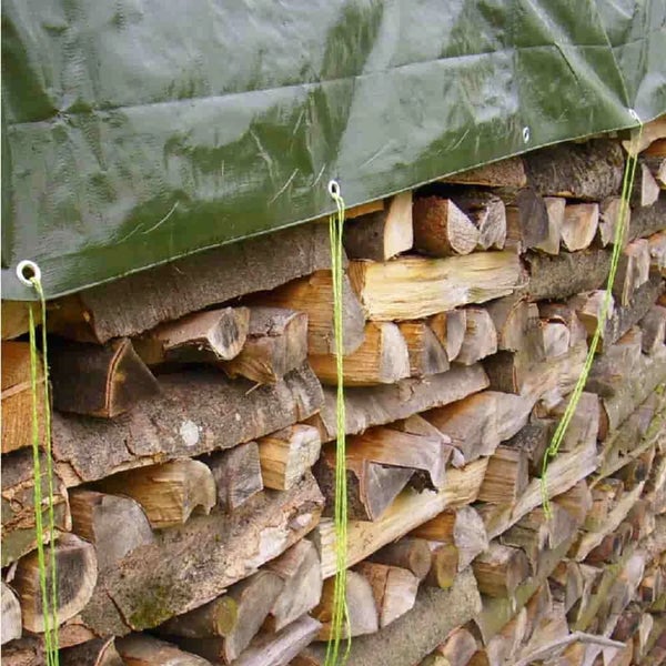 Eine wetterfeste Abdeckplane schützt einen ordentlich aufgeschichteten Holzstapel im Außenbereich.