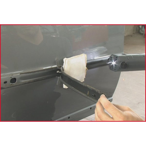 Detailansicht einer Autotür bei der Bearbeitung von Rost mit einem Rostentferner-Werkzeug.