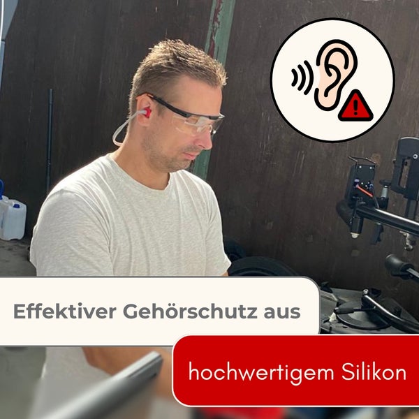 Ein Mann in einer Werkstatt trägt eine Schutzbrille und einen effektiven Gehörschutz aus Silikon mit Verbindungskabel.