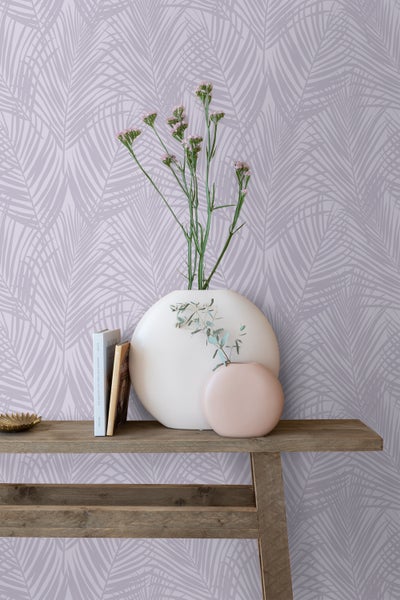 Dekorative Szene mit gemusterter Tapete, Vasen, Büchern und einem Holztisch