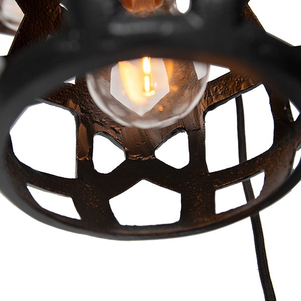 Detailansicht einer dekorativen Lampe mit geometrischen Aussparungen und einer Glühbirne