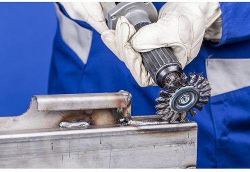 Drahtbürstenaufsatz in Verwendung auf Metalloberfläche