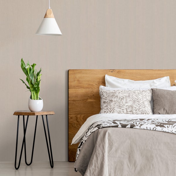 Schlafzimmer mit Holzbett, Nachttisch, Lampe und Zimmerpflanze