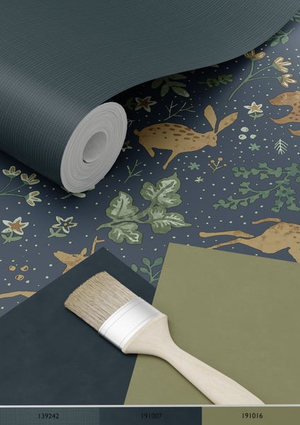 Tapetenrolle mit Tiermuster, Farbfelder und ein Pinsel.