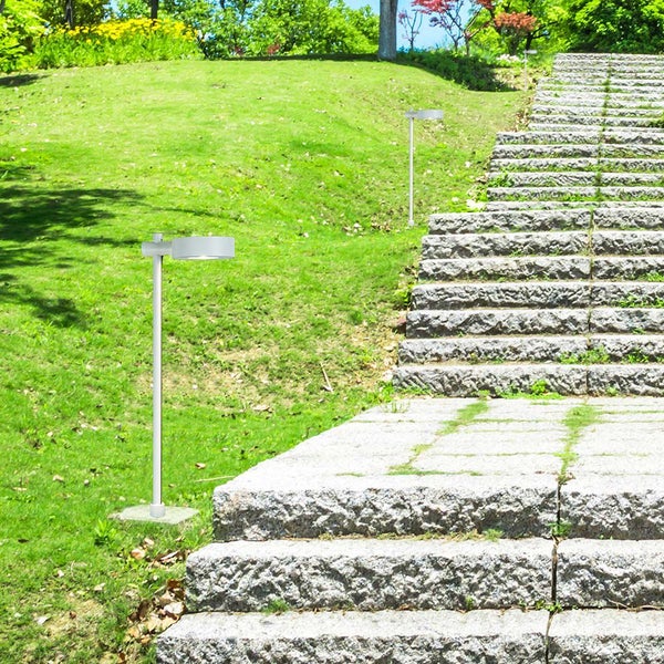 Szene mit einer Gartenleuchte neben einer Steintreppe in einem Garten.