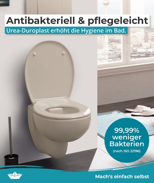 Wand-WC aus antibakteriellem Urea-Duroplast mit hochgeklapptem WC-Sitz in einem Badezimmer.