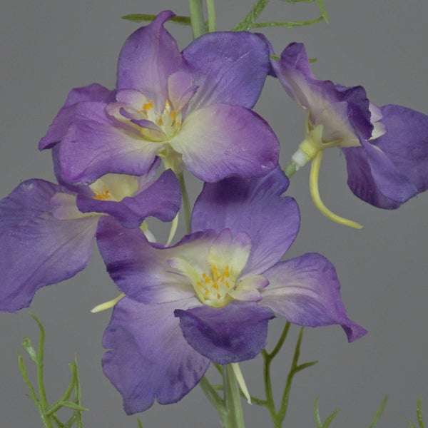 Künstlicher Rittersporn Zweig mit mehreren violetten Blüten und grünem Stiel.