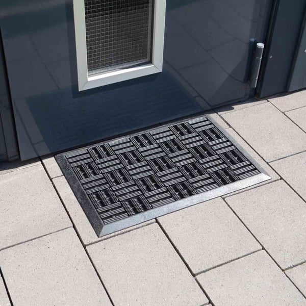 Fußmatte vor einer Haustür auf Steinboden