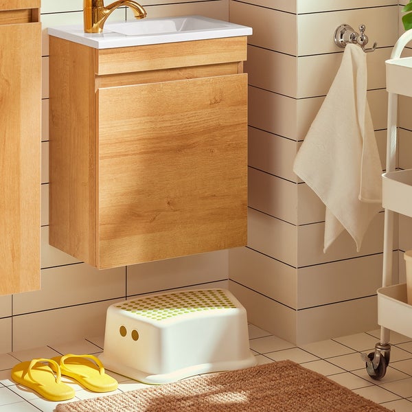 Badezimmer mit Waschtischunterschrank, Hocker und Handtuch