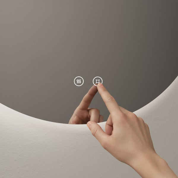 Hand bedient einen runden Badezimmerspiegel mit beleuchteten Touch-Symbolen für Licht und Antibeschlag-Funktion.
