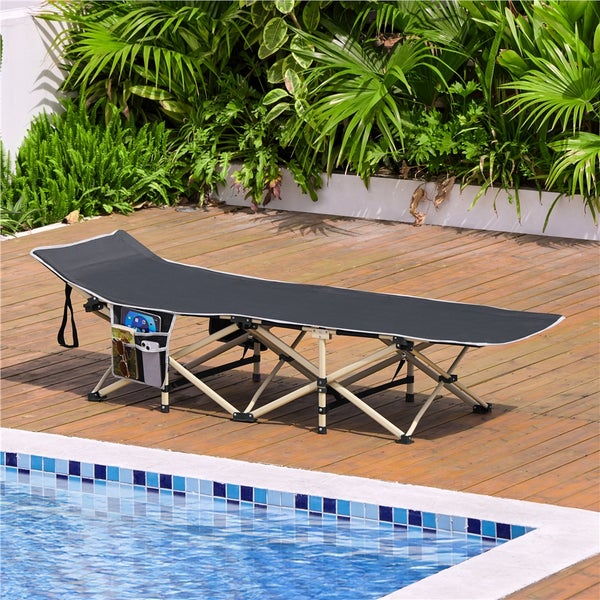 Graue Sonnenliege mit Beistelltasche neben einem Swimmingpool