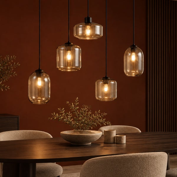 Moderne Hängeleuchte mit fünf gläsernen Lampenschirmen über einem dunklen Esstisch in einem eleganten, stimmungsvoll beleuchteten Esszimmer.