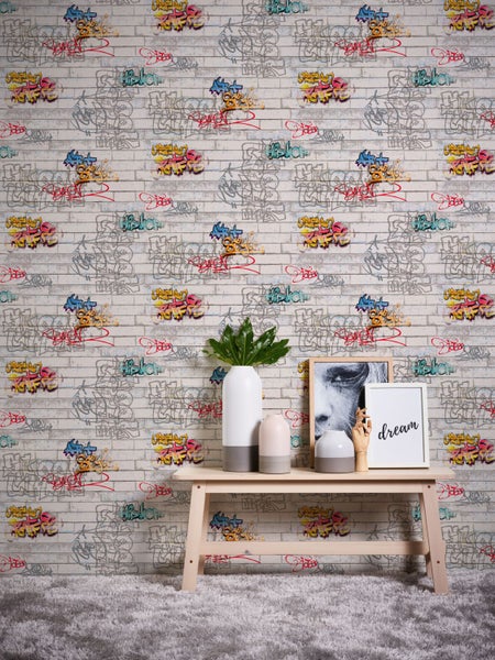 Wand mit Graffiti-Tapete, dekoriert mit Vasen und Bildern auf einem Holztisch.