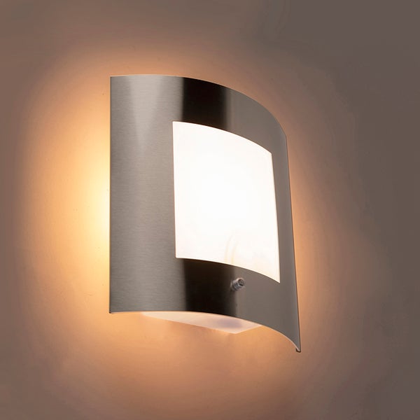 Gebogene Außenwandleuchte aus Edelstahl mit Bewegungsmelder und mattem Diffusor, eingeschaltet mit warmem Licht.