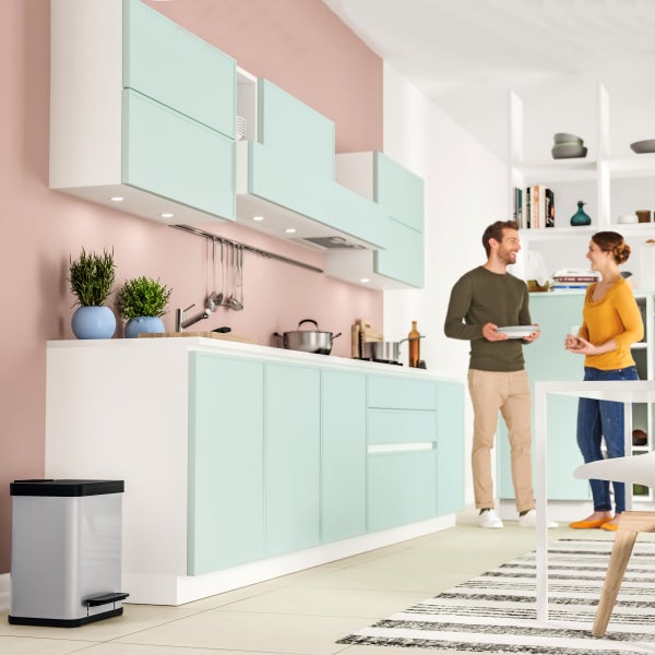 Moderne Küche mit hellen Fronten, Edelstahl Mülleimer und zwei Personen im Gespräch