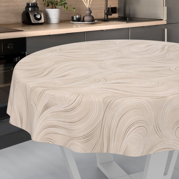 Runde Tischdecke mit beigem Wellenmuster auf einem Tisch in einer hellen, modernen Küche mit Arbeitsplatte in Holzoptik.