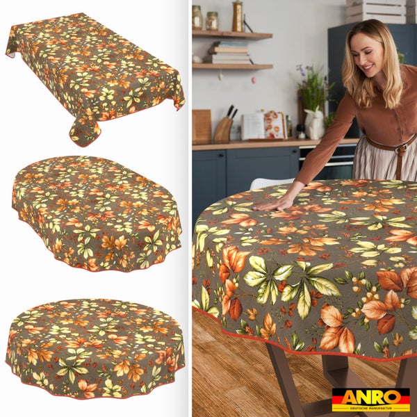 Abwaschbare Tischdecken in eckig, oval und rund mit Herbstlaub-Muster. Szene in heller Küche mit Frau am Tisch. Anro Deutsche Manufaktur Logo.